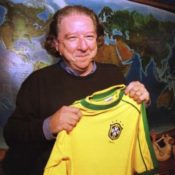 Soccer Legend Aldyr Schlee holds jersey he designed